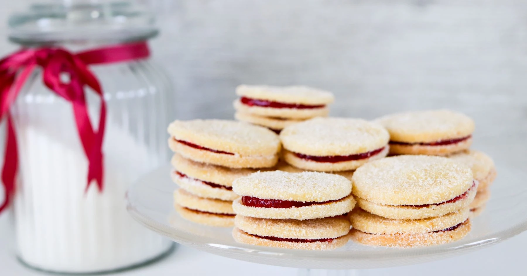 Herrasväen pikkuleipiä päällekkäin tarjoilulautasella.