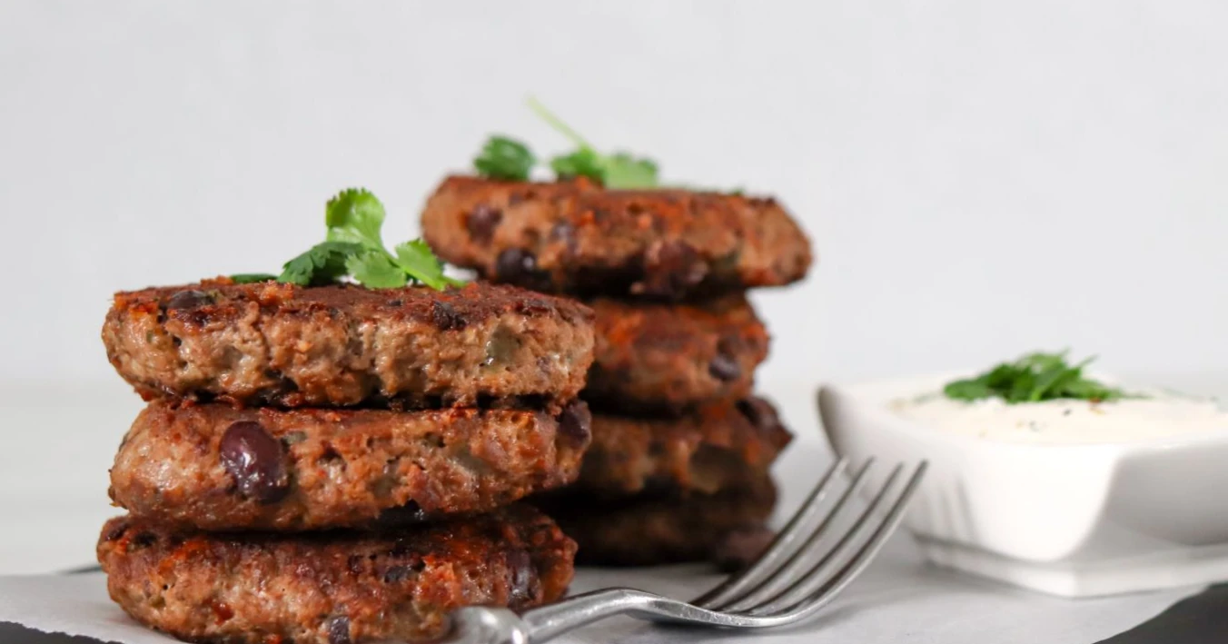 Jauheliha-papupihvejä, jogurttikastiketta ja korianterin lehtiä.