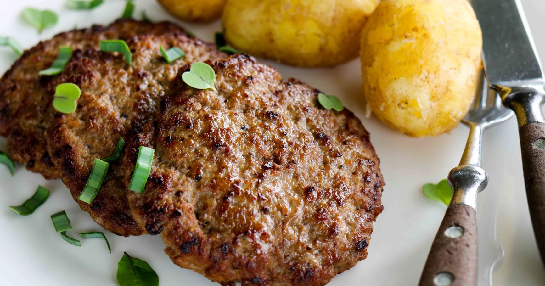 Jauhelihapihvit keitettyjen perunoiden kanssa.