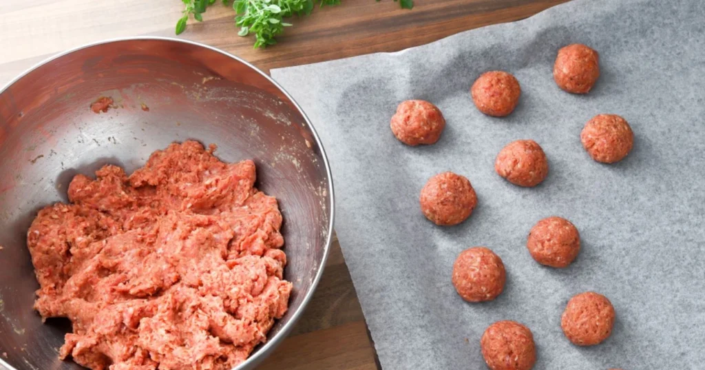 Jauhelihataikina, josta on tehty lihapullia pellille.