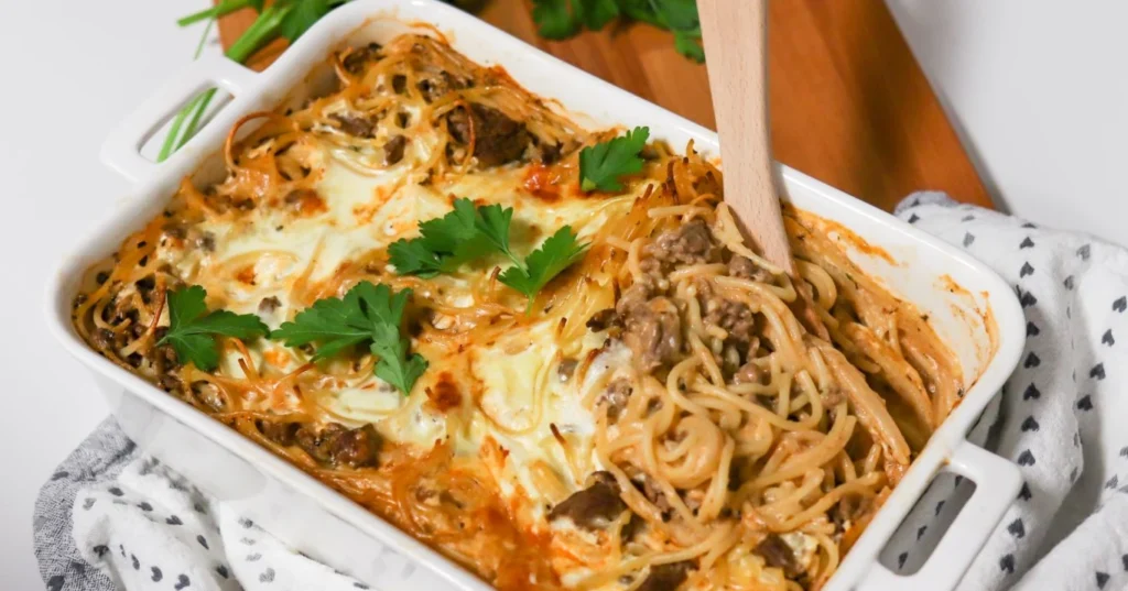 Spagetti-jauhelihavuoka lehtipersiljalla koristeltuna.