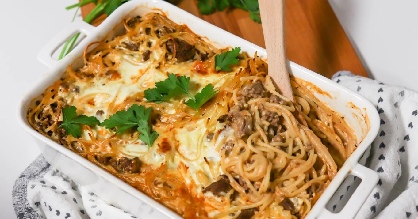 Spagetti-jauhelihavuoka lehtipersiljalla koristeltuna.