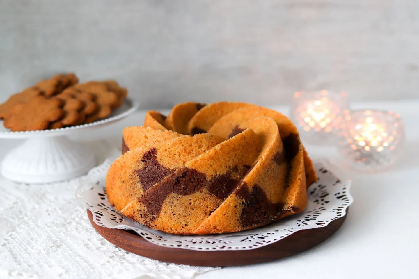 Jouluinen tiikerikakku, jonka takana palavat tuikkukynttilät.