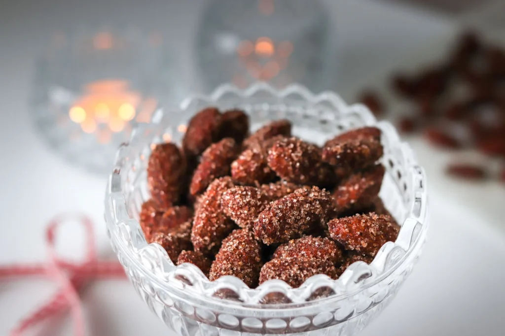 Kanelilla ja sokerilla kuorrutetut joulumantelit pienessä lasikulhossa.