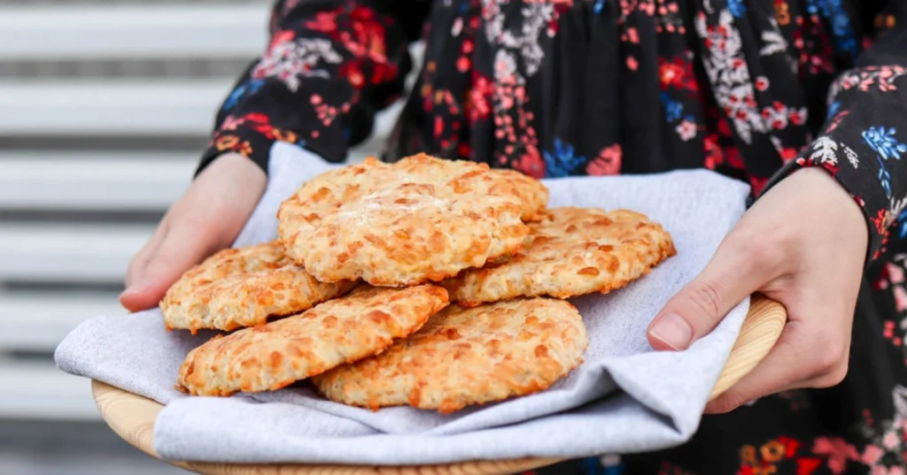 Juustoleipäset tarjoilulautasella vaalean liinan päällä.