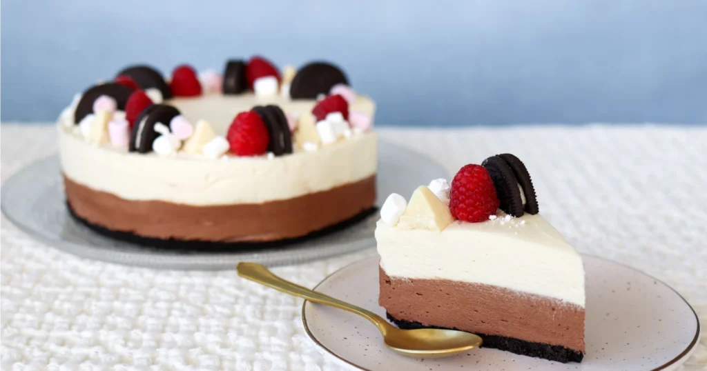 Kahden suklaan juustokakku, josta on leikattu yksi pala lautaselle.