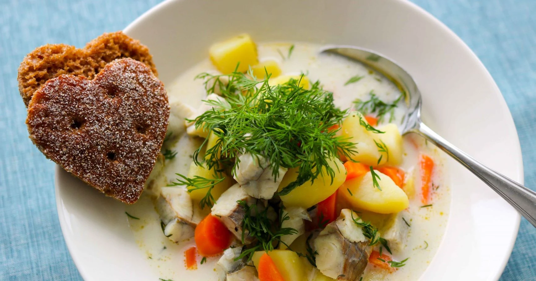 Kalakeitto seistä valkoisella lautasella ruisleivän kanssa.