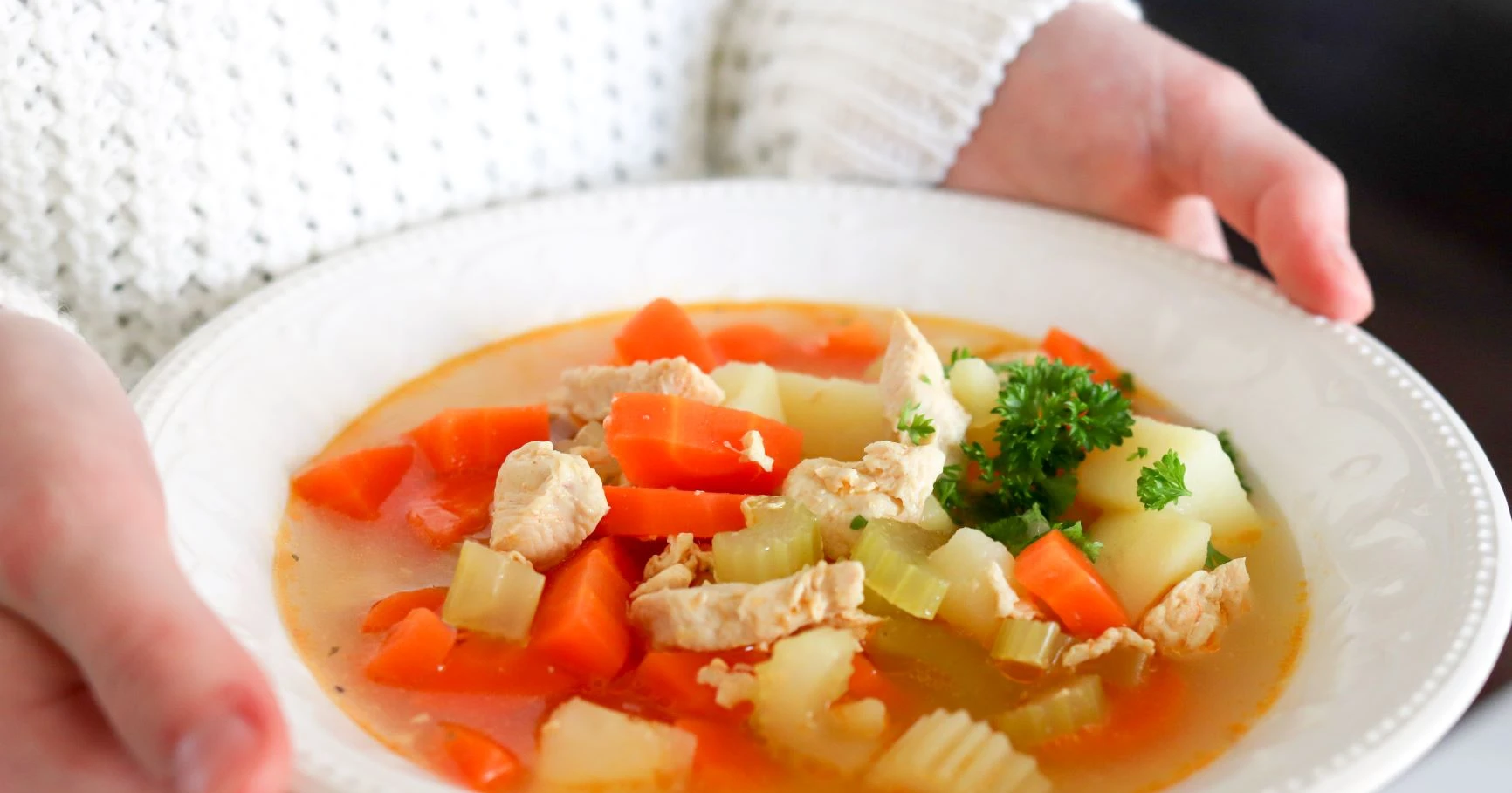 Kanakeitto, jossa on perunoita, valkoisella lautasella.