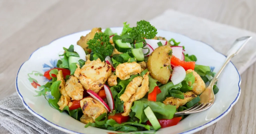 Kanasalaatti kukallisella lautasella.