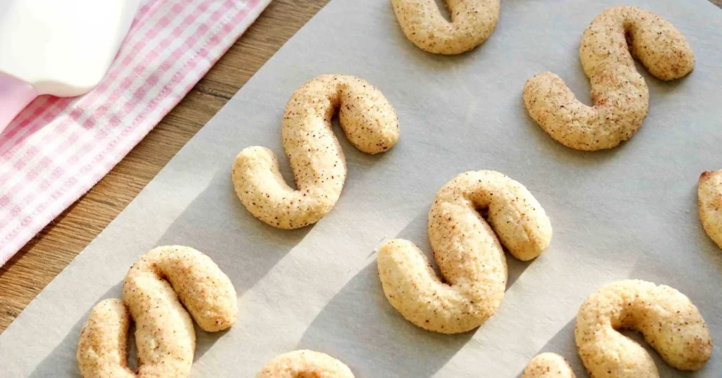 Gluteenittomia kaneliässiä uunissa paistamisen jälkeen jäähtymässä leivinpaperilla.