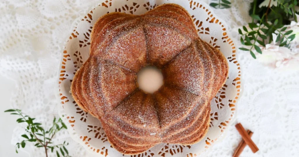 Kanelikakku puisella tarjoilulautasella, jolla on kakkupaperi