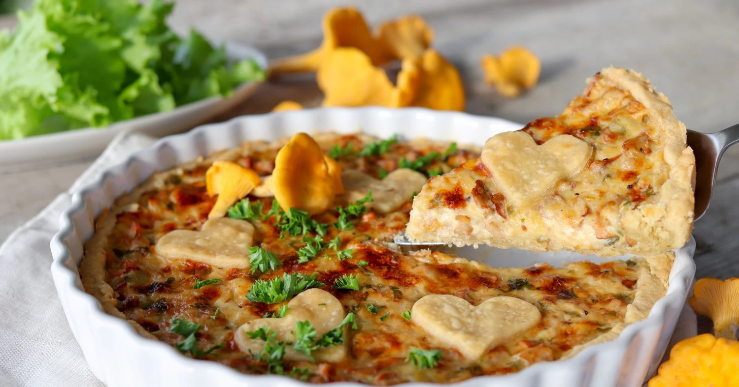 Kantarellipiirakka ja tuoreita keltaisia kantarelleja.