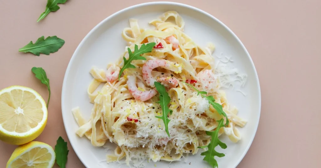 Katkarapupasta rucolalla ja juustolla koristeltuna.