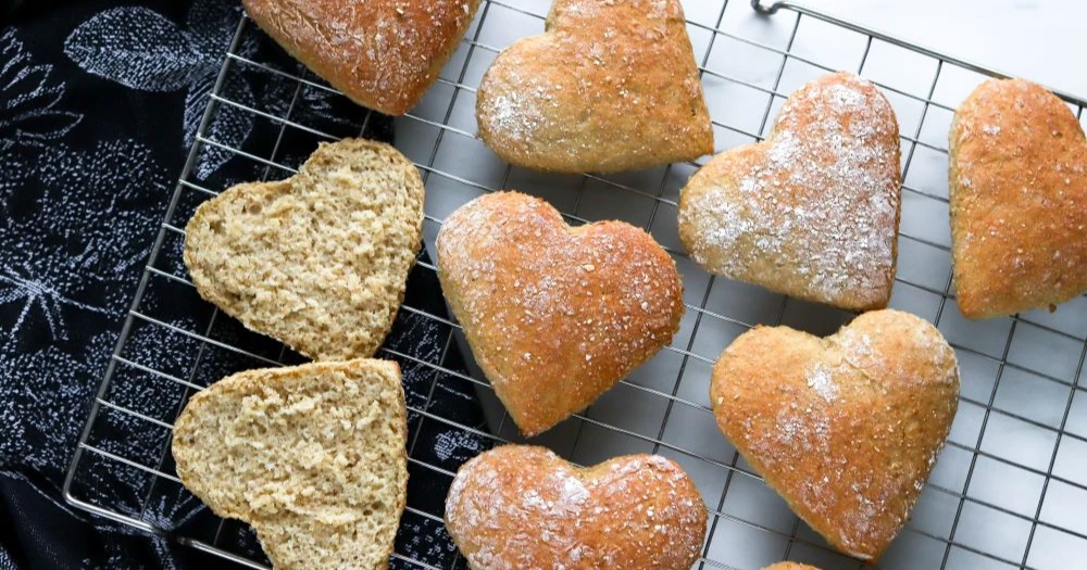 Kaurasydän halkaistuna sekä halkaisemattomia leipiä ritilällä.