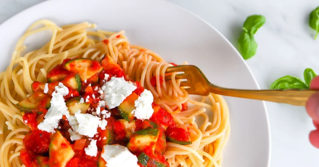 Kesäkurpitsapasta, jonka päälle on ripoteltu fetajuustoa.