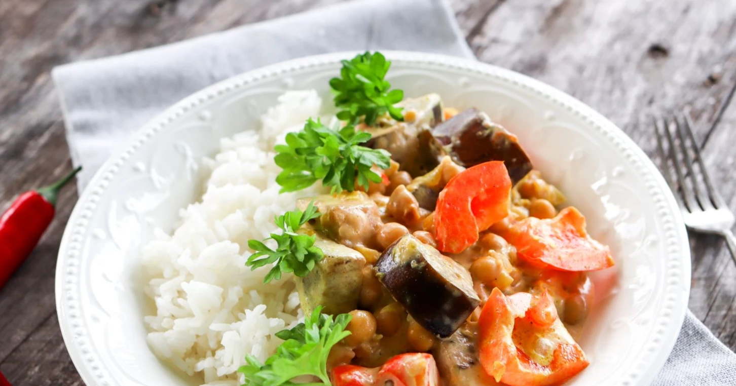 Kikhernecurry ja riisiä valkoisella lautasella.