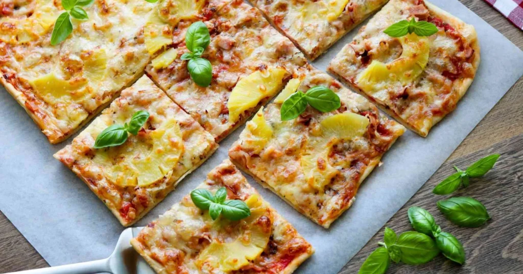 Kinkkupizza tuoreella basilikalla koristeltuna.