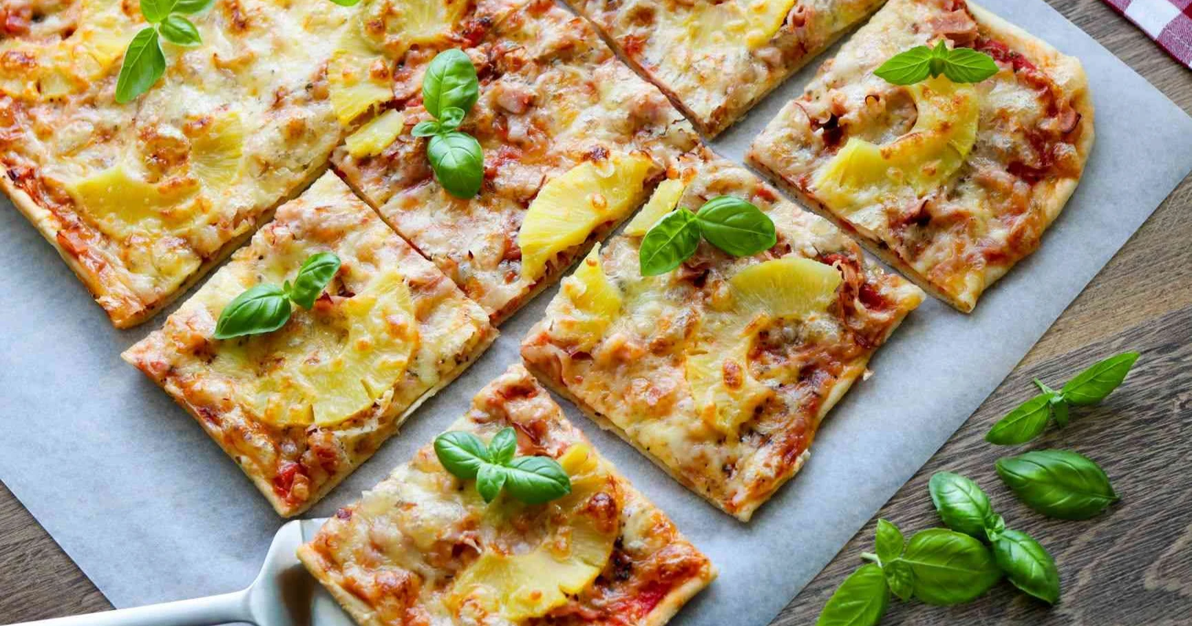 Kinkkupizza tuoreella basilikalla koristeltuna.