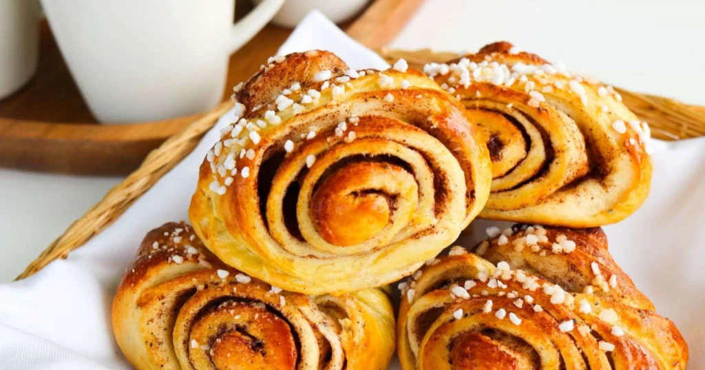 Korvapuustit valkoisen liinan päällä.