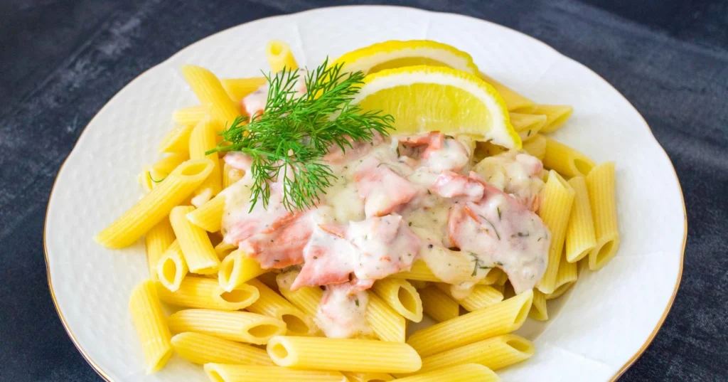 Kylmäsavulohipasta tuoreella tillillä ja sitruunalla koristeltuna.