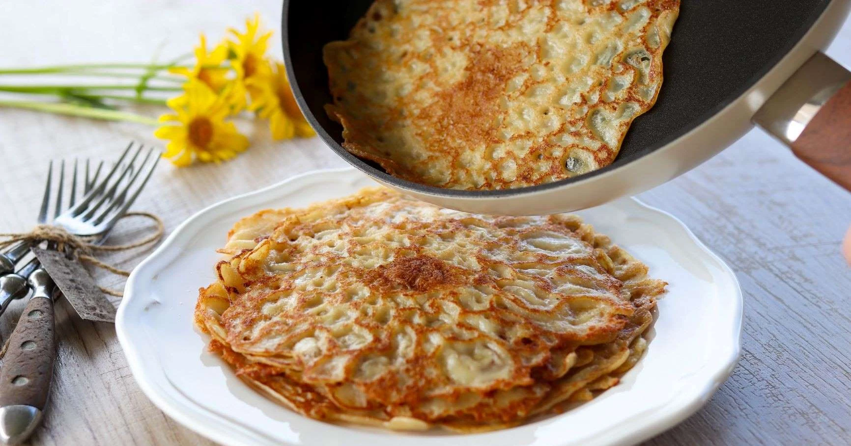 Vegaaninen lettu, jota kaadetaan lautaselle paistinpannulta.