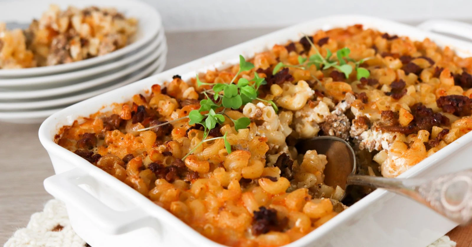 Lihamakaronilaatikko uunivuoassa sekä lautasella.