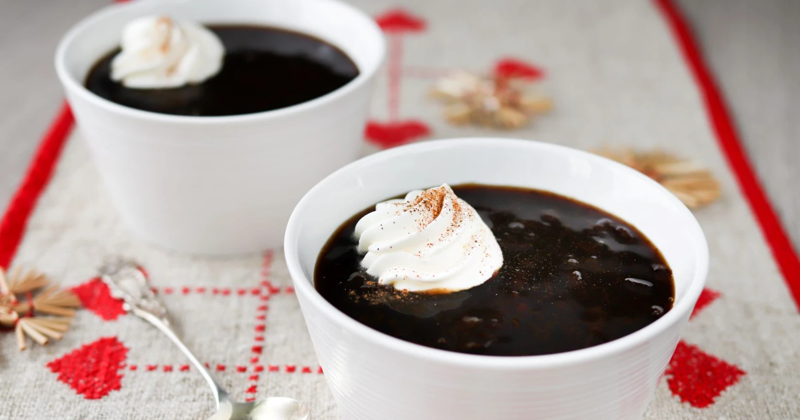 Luumukiisseli kulhossa kermavaahdolla koristeltuna.