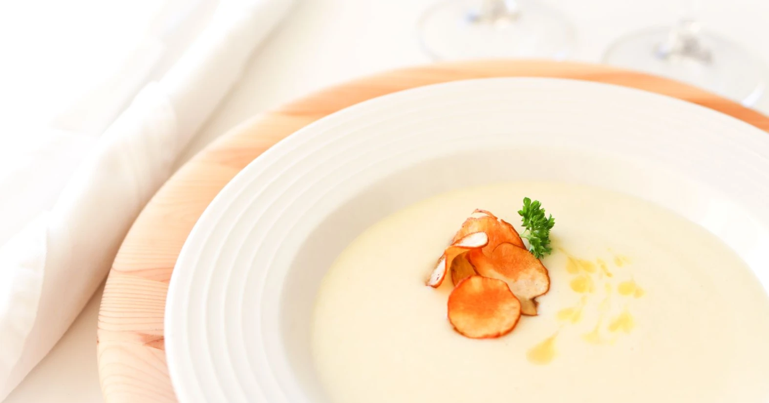 Maa-artisokkakeittoa paahdetulla lastulla koristeltuna.