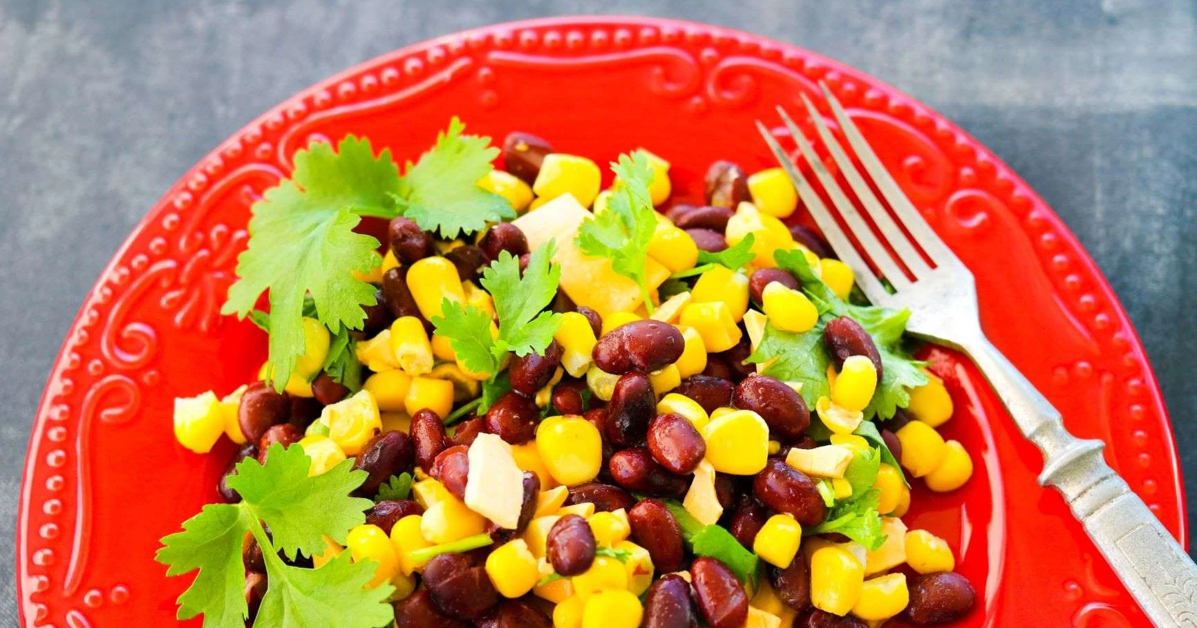 Maissisalaatti punaisella lautasella.