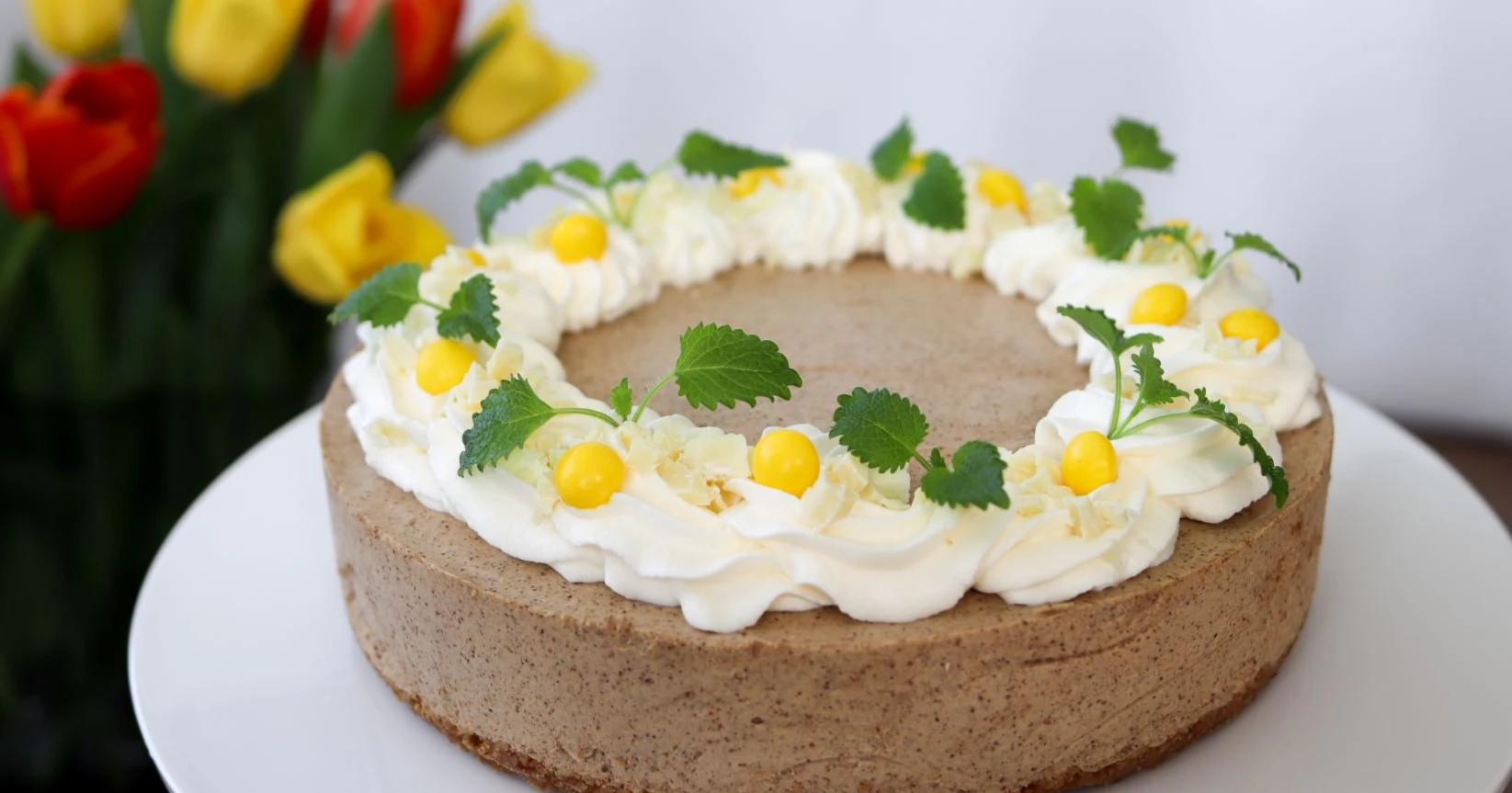 Mämmikakku kermavaahdolla ja pääsiäismakeisilla koristeltuna.