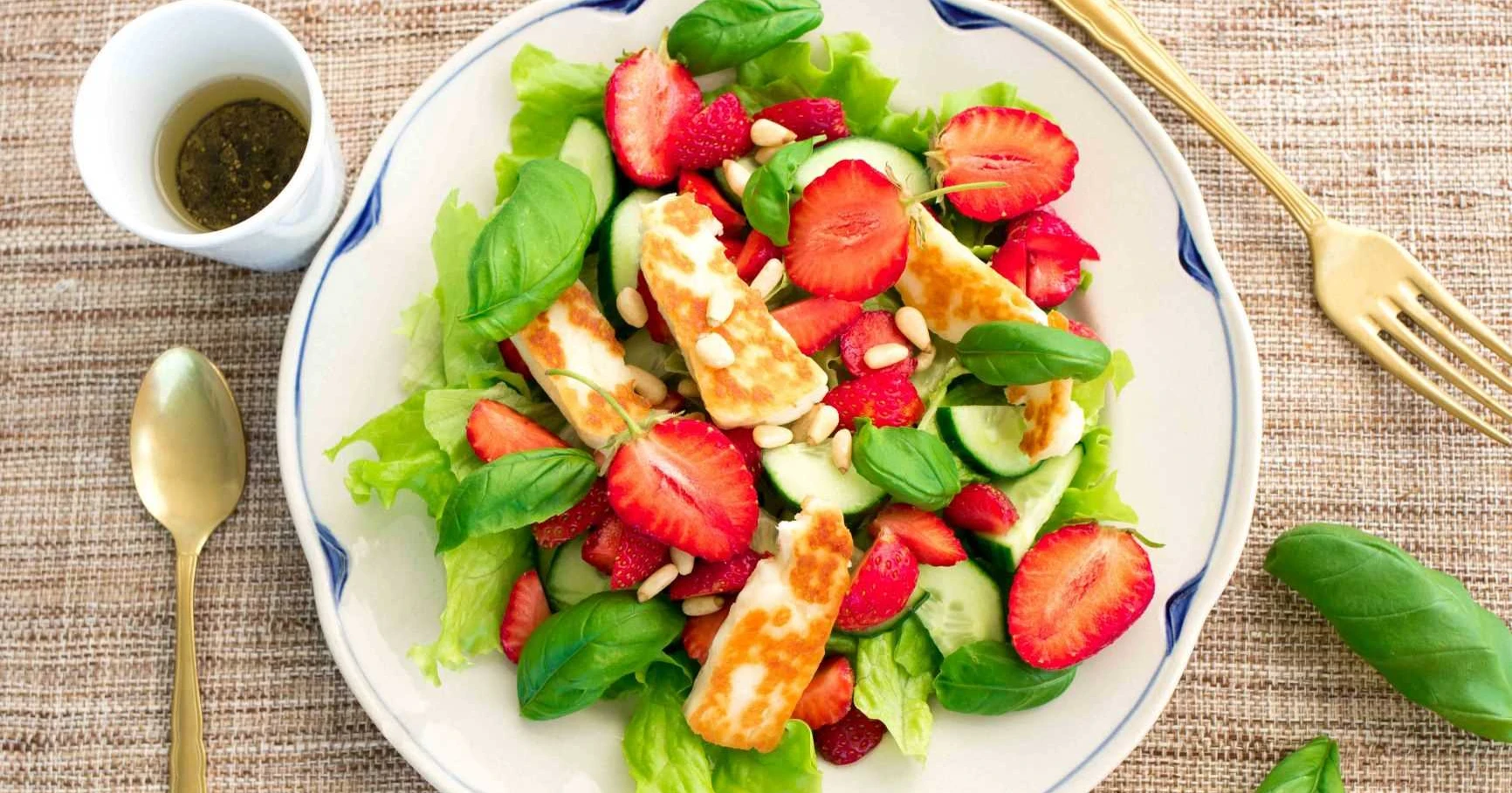 Mansikka-halloumisalaatti vanhalla lautasella.