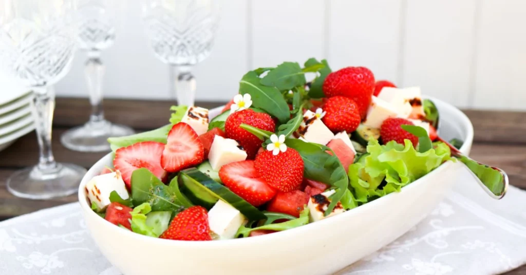 Upea mansikkasalaatti vaaleassa tarjoilukulhossa.
