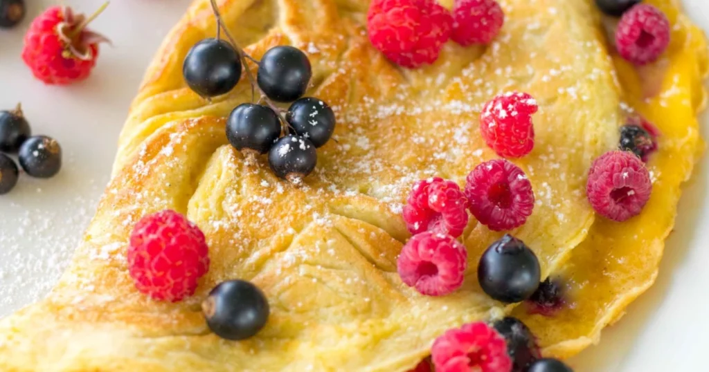 Marjamunakas, jonka päällä on tuoreita vadelmia ja mustaherukoita.