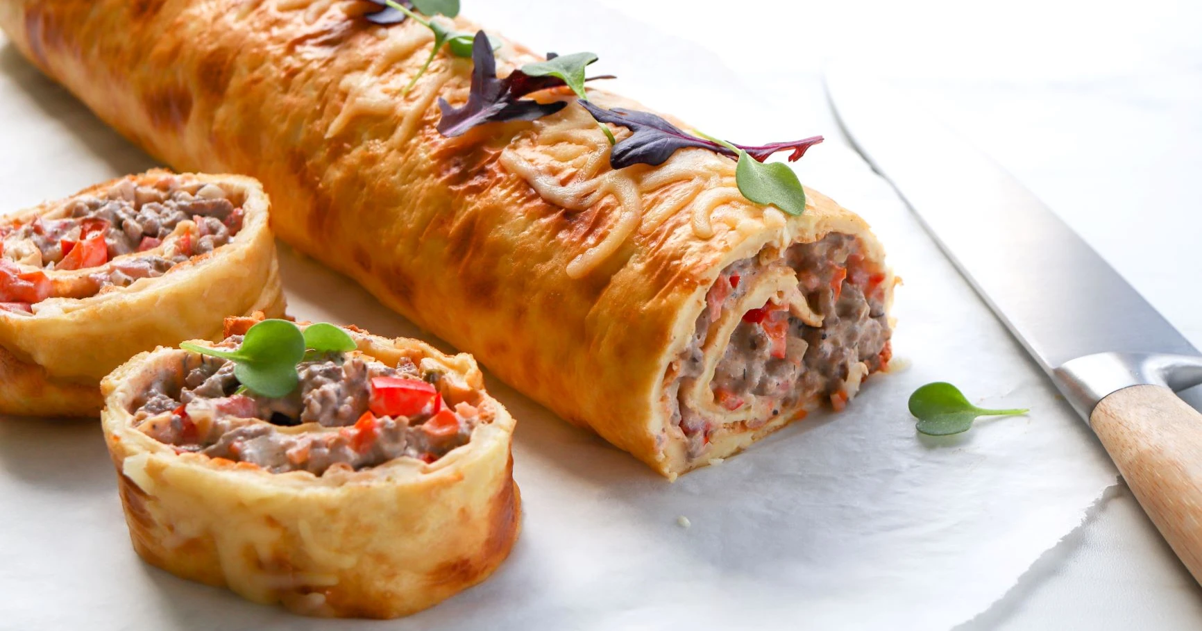 Munakasrulla jauhelihatäytteellä pariksi viipaleeksi leikattuna.