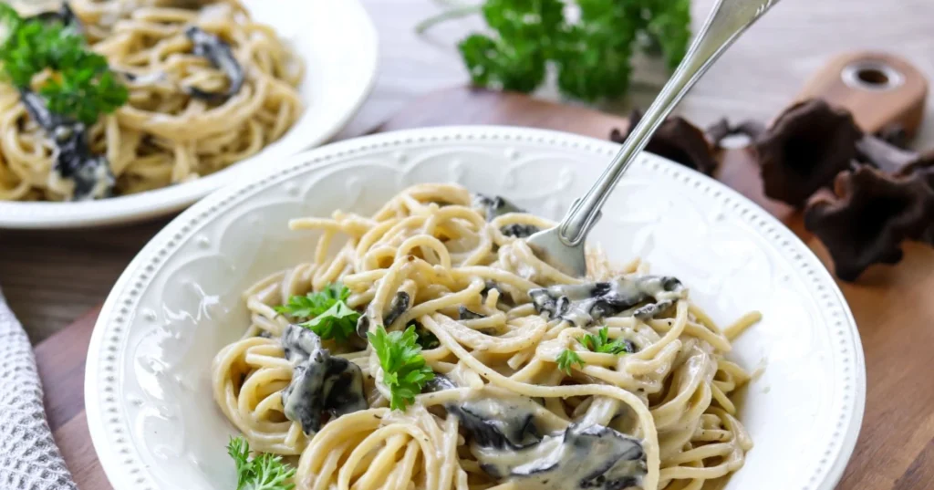 Mustatorvisienikastike pastan kanssa lautasella.