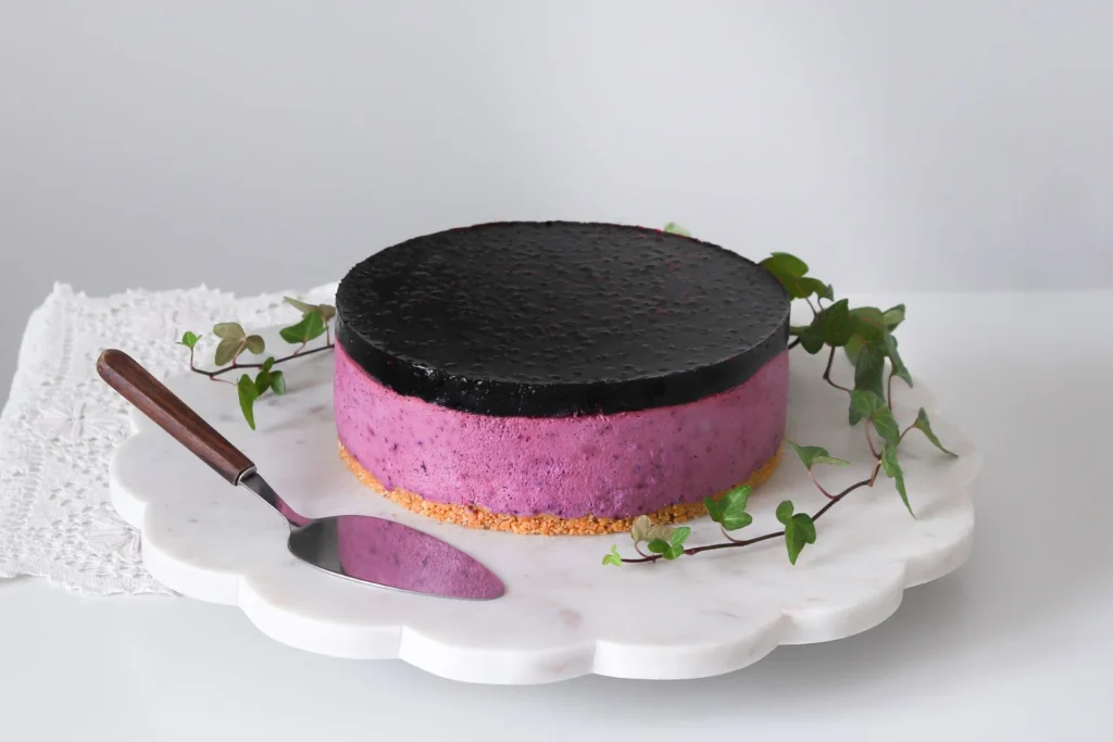 Mustikkajuustokakku, jossa on mustikoista tehty tumma kiille.