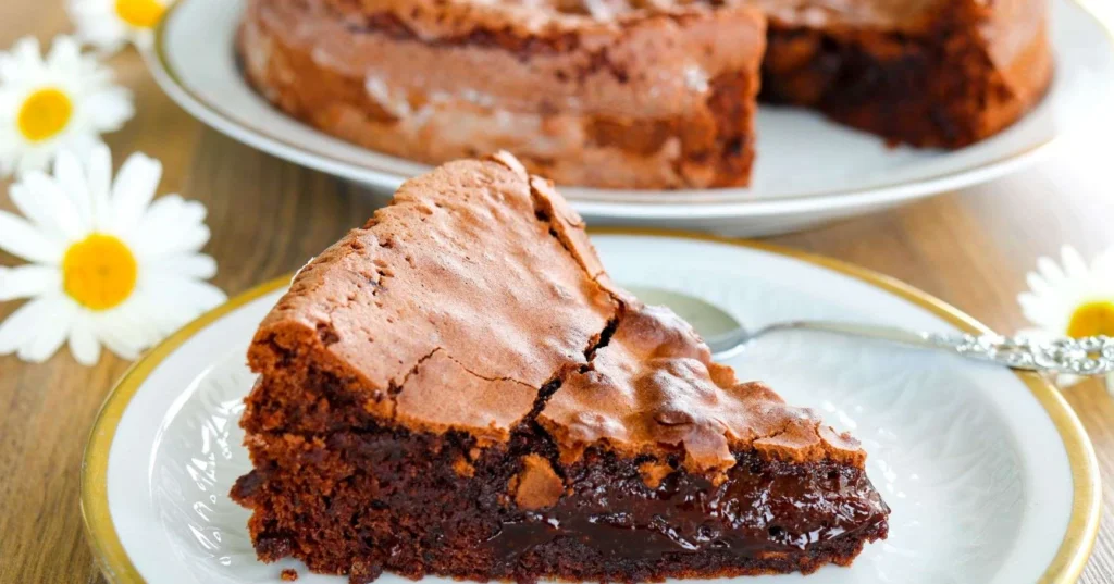 Mutakakku-pala lautasen päällä ja päivänkakkaroita.