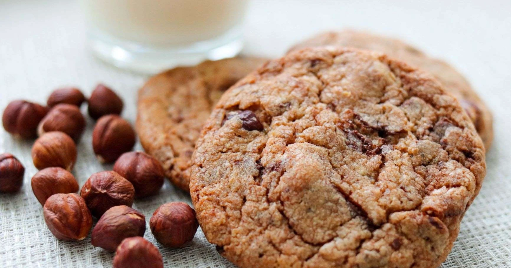 Nutella-keksejä ja hasselpähkinöitä valkoisella pöydällä.