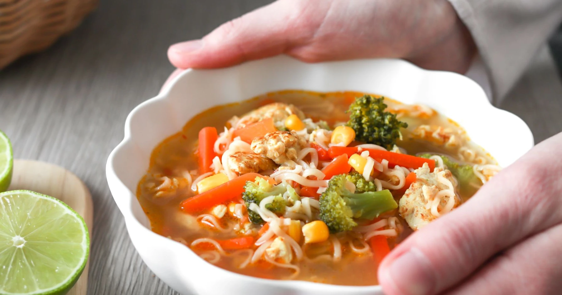 Nuudeli-kanakeitto valkoisessa kulhossa, jossa on aaltoileva reuna.