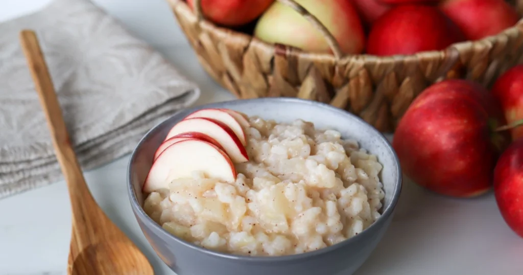 Omenariisipuuro kulhossa omenanviipaleilla koristeltuna.