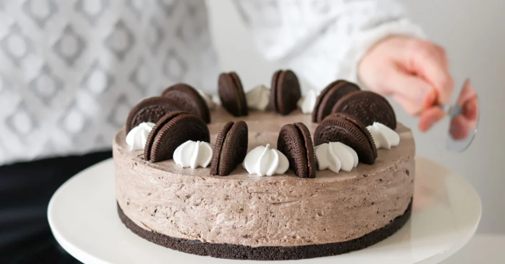 Oreo-kakku koristeltuna puolitetuilla kekseillä ja marengeilla.