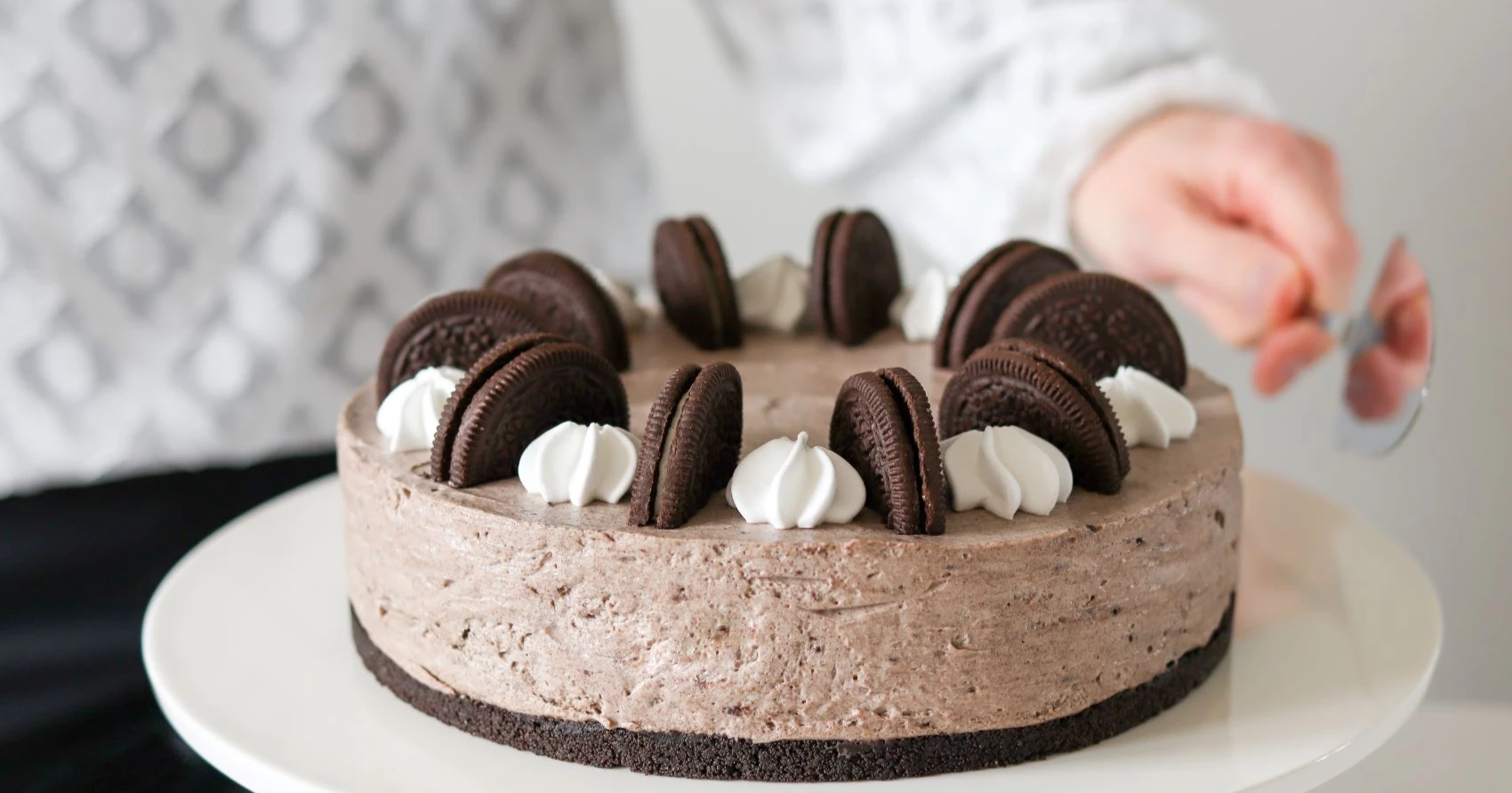 Oreo-kakku koristeltuna puolitetuilla kekseillä ja marengeilla.