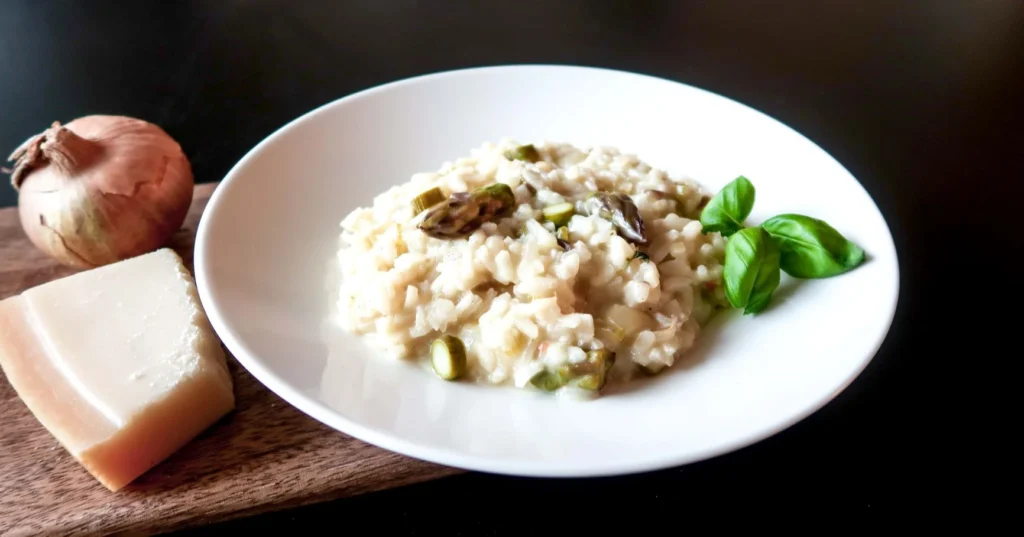 Parsarisotto ja parmesaanijuustoa valkoisella lautasella.