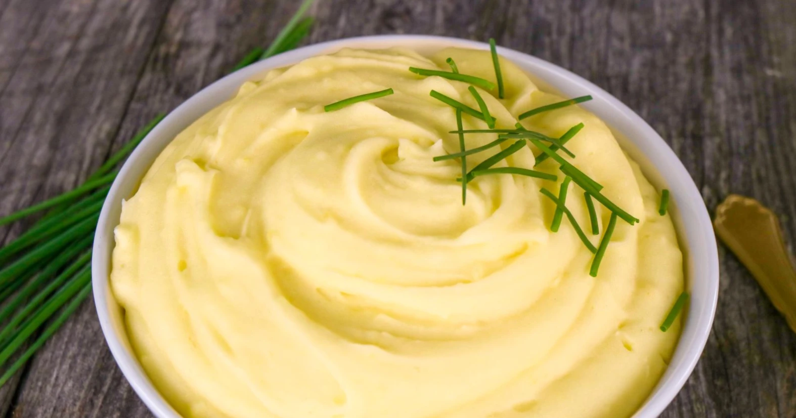 Perunamuusi kulhossa ja ruohosipulia.