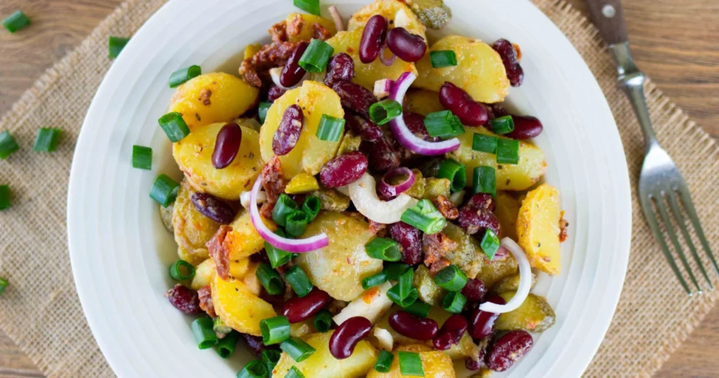 Kirkas perunasalaatti tuoreella vihreällä sipulin varrella koristeltuna.