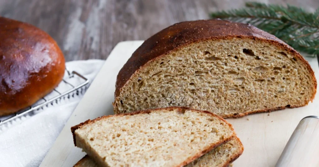 Piimälimppu leikkuulaudalla viipaleiksi leikattuna.