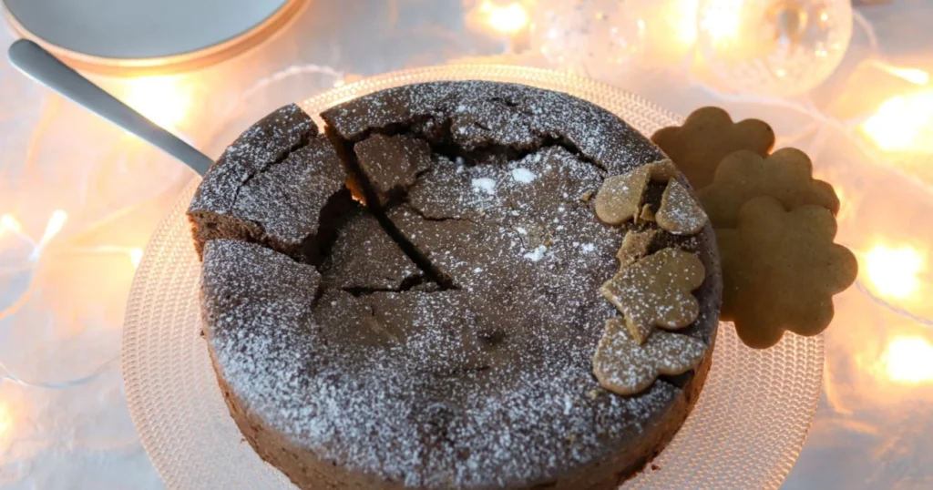 Piparimutakakku pöydässä, joka on koristeltu jouluvaloilla.