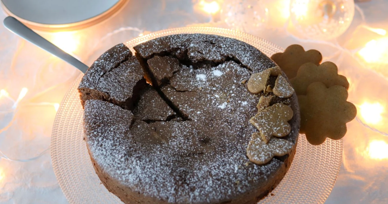 Piparimutakakku pöydässä, joka on koristeltu jouluvaloilla.