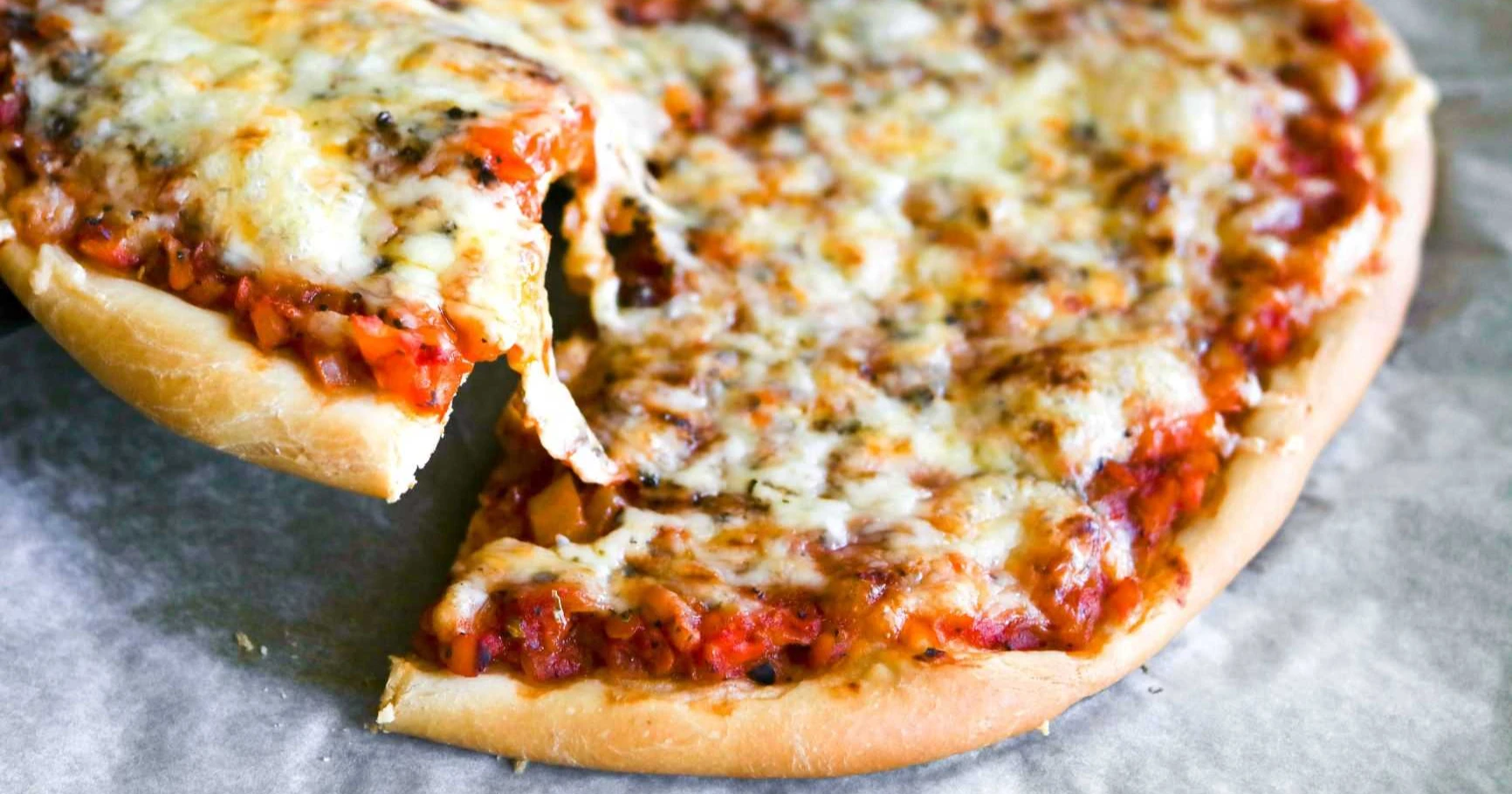 Pizzapohja kuivahiivalla kohotettuna, täytettynä ja paistettuna.