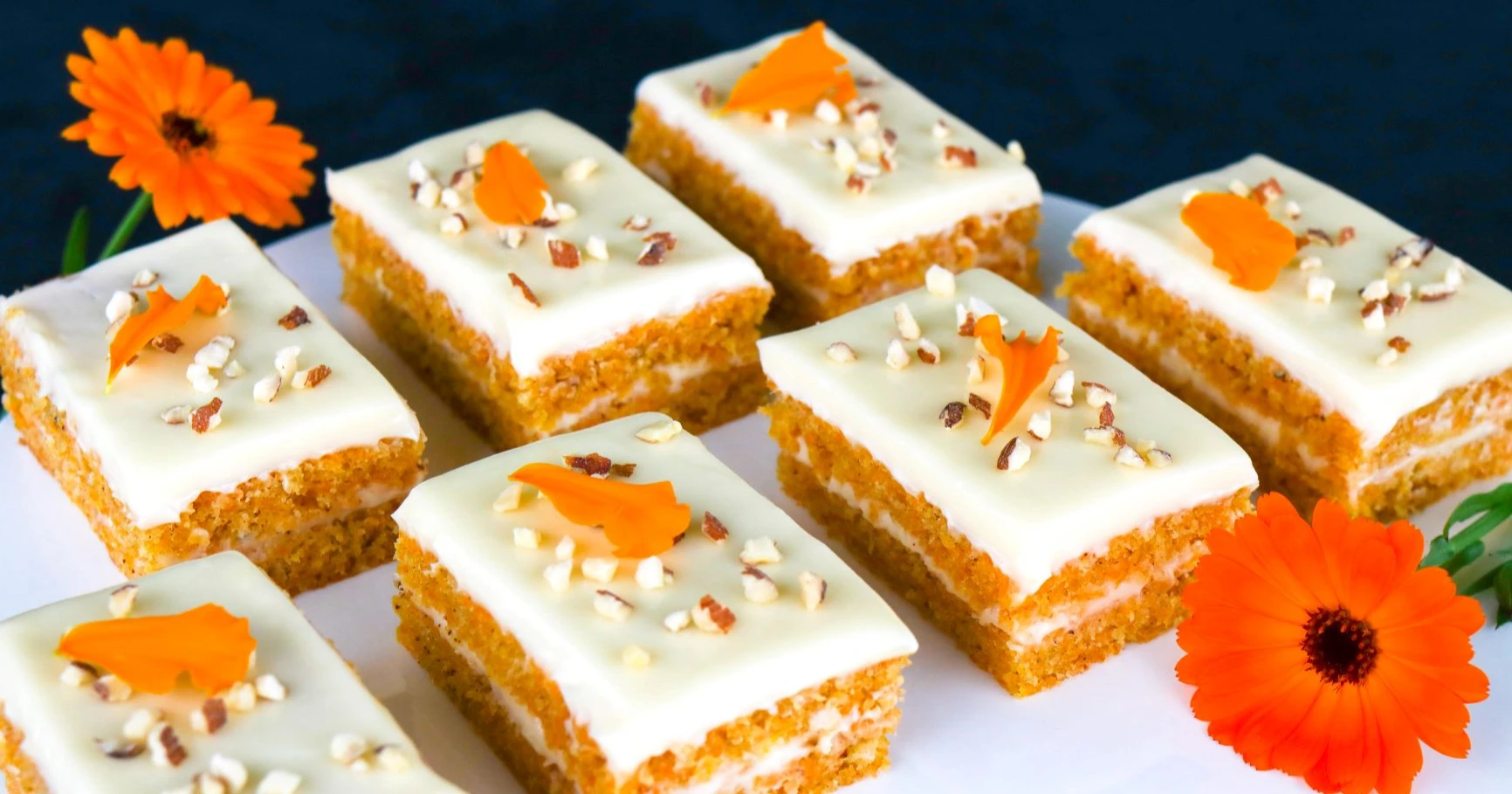 Pellillä paistettu mehevä porkkanakakku, jonka päällä on pähkinärouhetta.